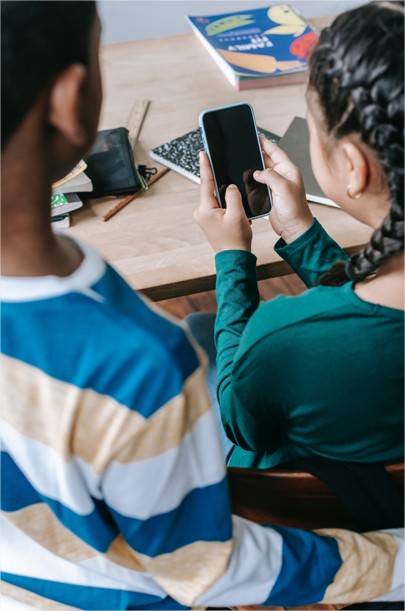 Enfants devant leur devoir avec un téléphone